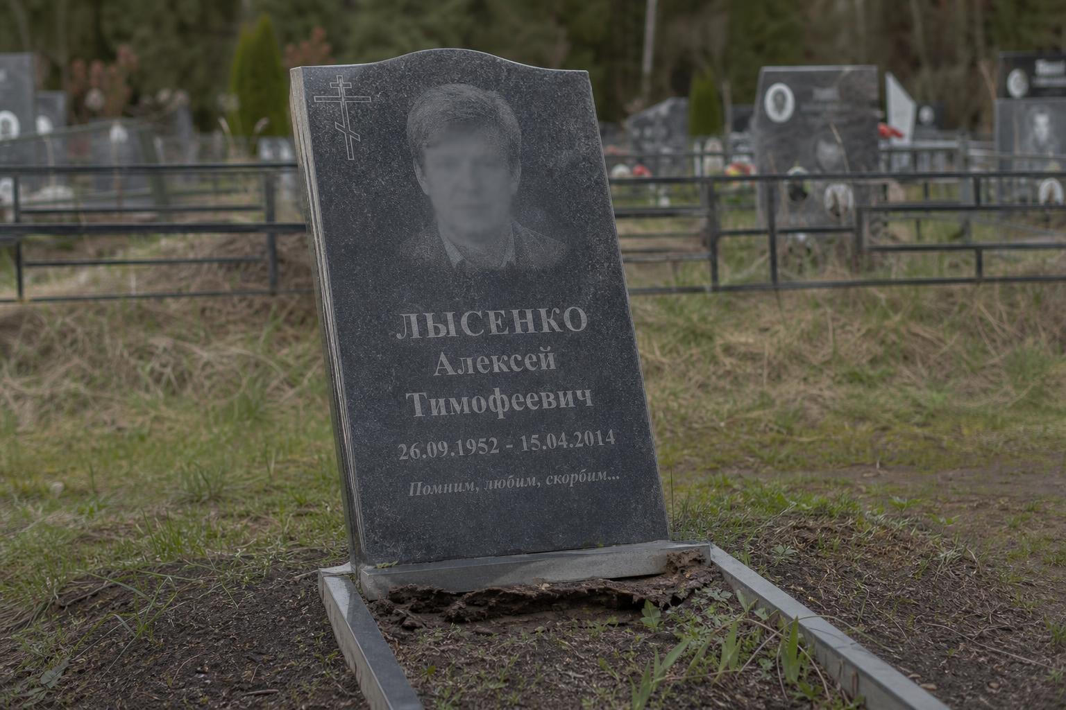 Наклонившийся гранитный памятник на могиле из-за неустоявшегося грунта